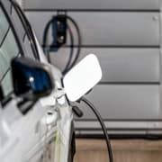 Hvid bil oplades med ladestander i garage