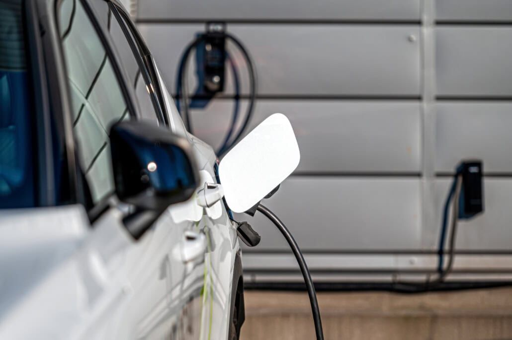 Hvid bil oplades med ladestander i garage