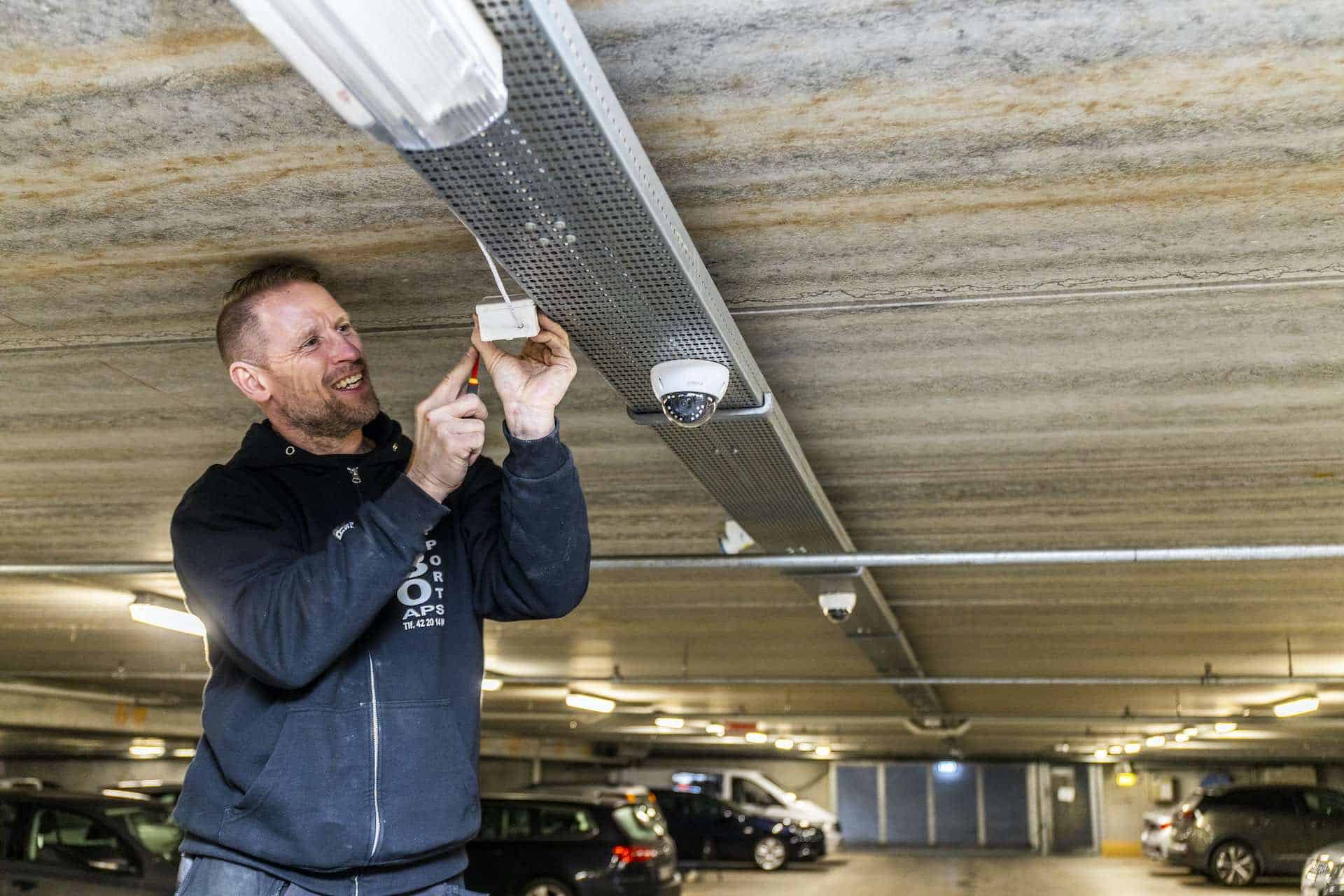 Elektriker opsætter sensor til automatiske lys i parkeringskælder